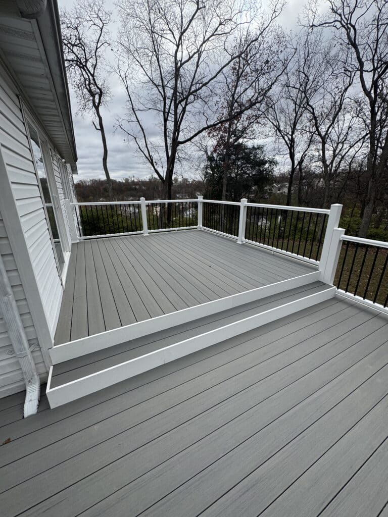 Gray composite deck with white vinyl railing and black balusters