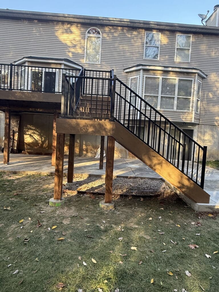 Black aluminum stair railing with deck lighting on an elevated deck