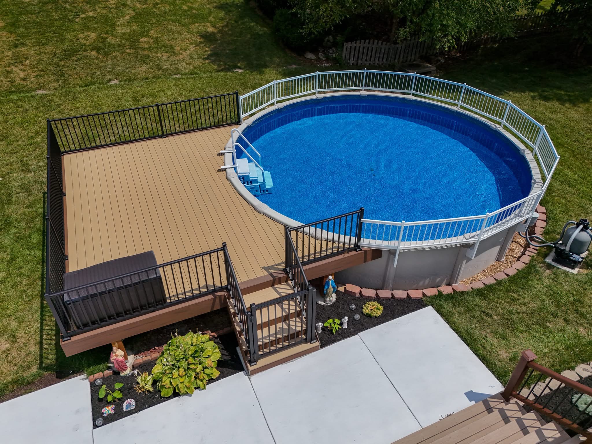Aerial view of a composite pool deck with black aluminum railing surrounding an above-ground pool