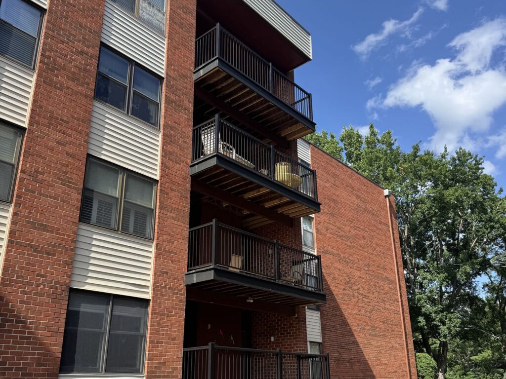 Four-story stack of condo balcony decks rebuilt with black aluminum railing, Creve Coeur MO