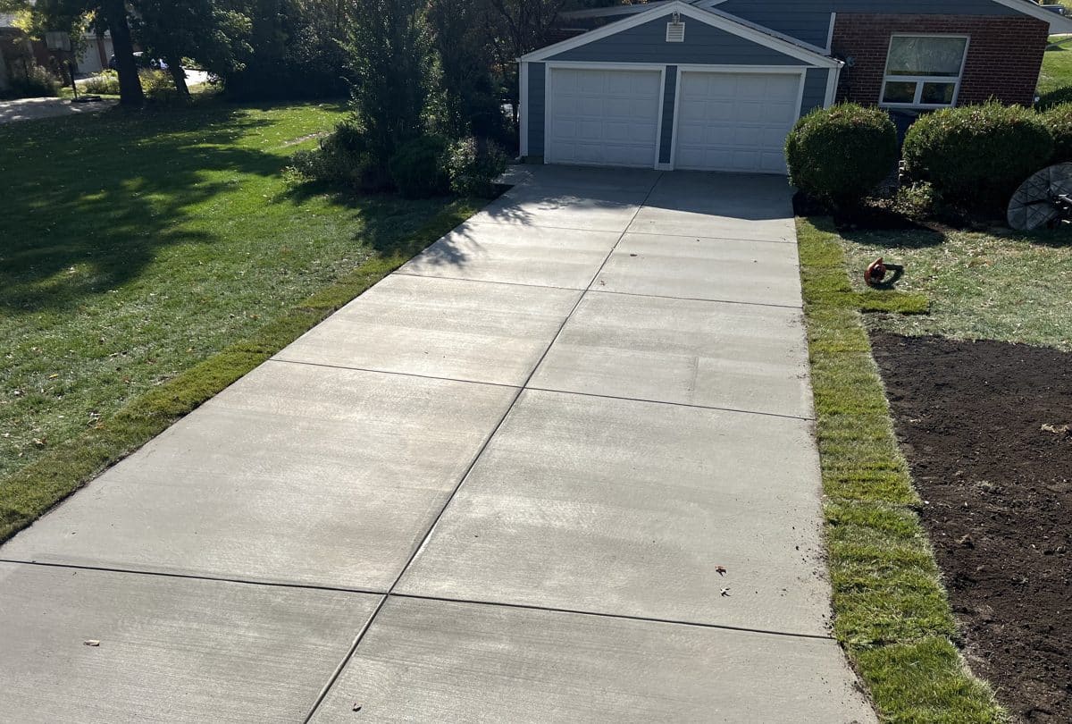 New broom finish concrete driveway with fresh sod borders in St. Louis