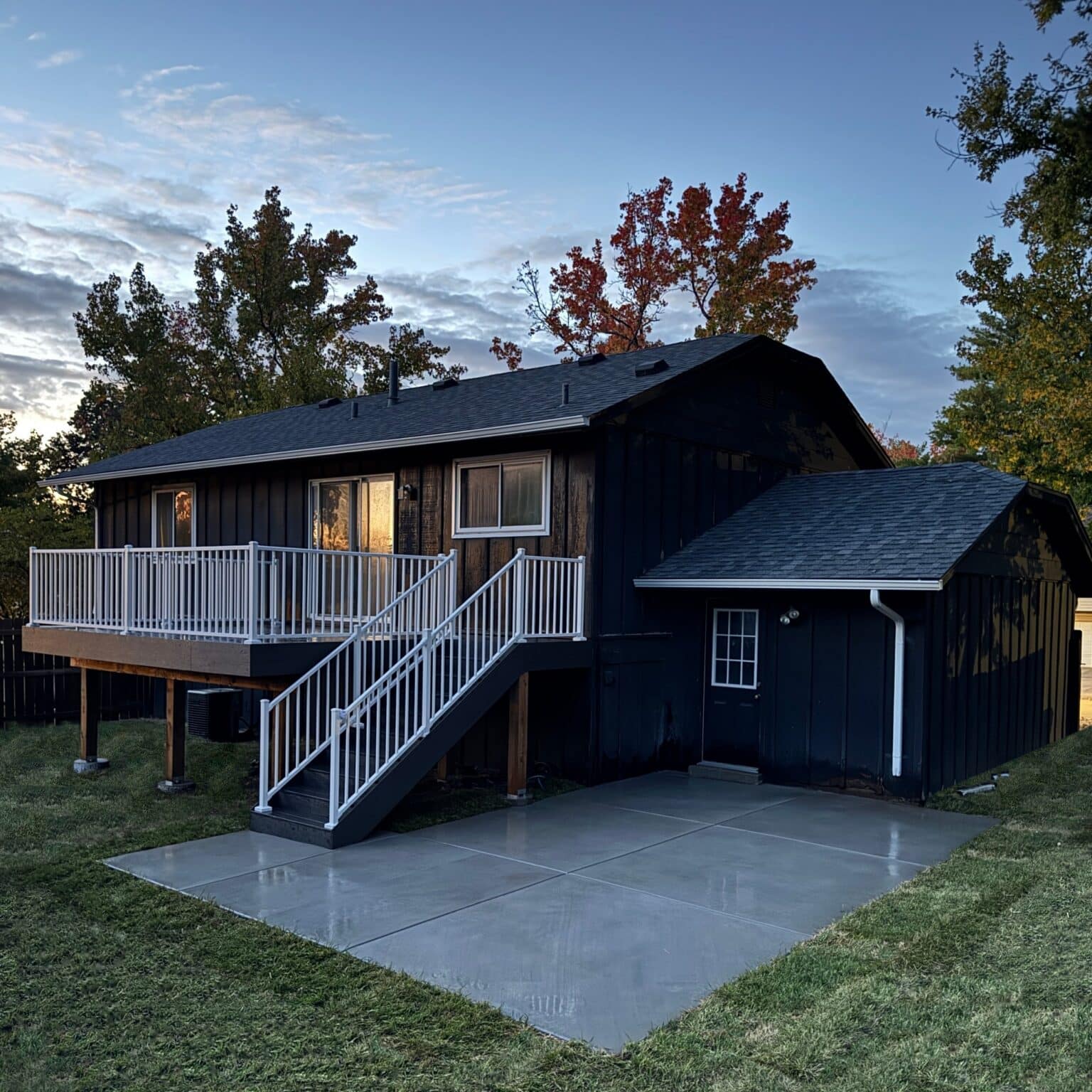 Elevated composite deck with white aluminum railing and a new concrete patio, St. Louis