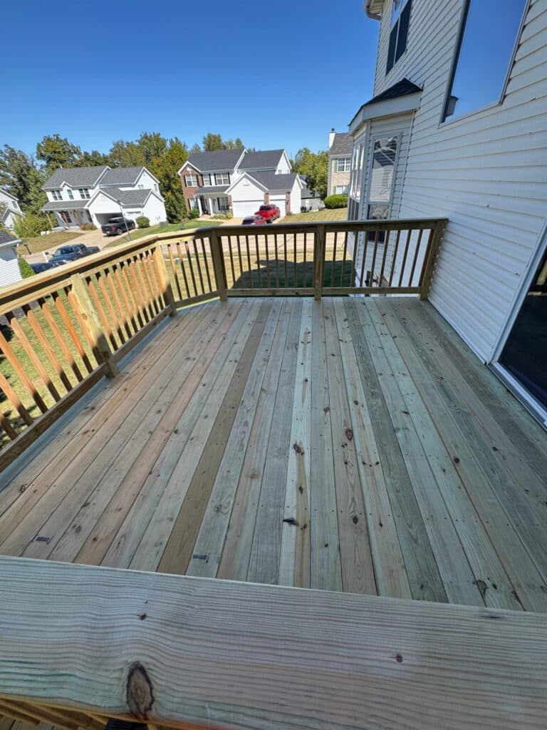 After: new deck boards and wood railing on a revamped deck